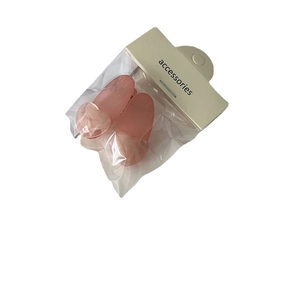 Paire de jolies barrettes en forme de cœur rose dans un emballage plastique