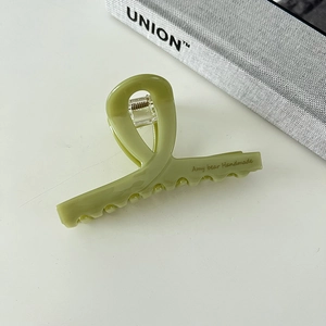 Detail of elegant green acetate shark hair clip with handmade lettering and strong spring