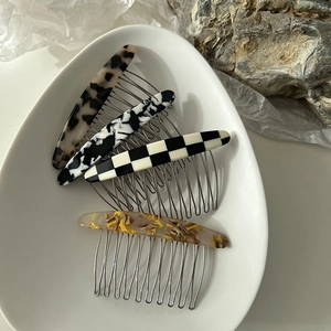 Peignes à cheveux élégants en acétate à motifs marbrés sur un plateau en céramique