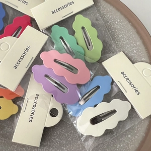 Lot de barrettes à cheveux en métal ondulé coloré aux tons pastel sur un plateau