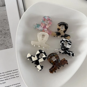 Set of 6 premium acetate hair claws in leopard, marble, and floral patterns on white tray