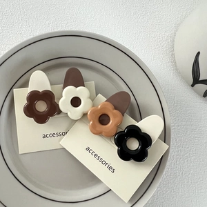 Set de barrettes à fleurs mates en marron et crème sur un plateau en céramique
