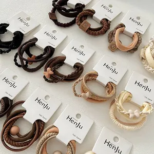 Detail of multi-texture elastic hair ties with bear and bow charms on paper cards