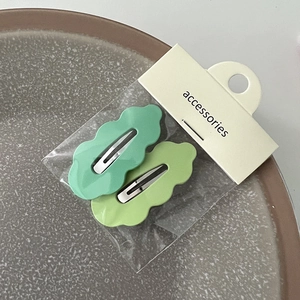 Gros plan de barrettes à cheveux ondulées vert menthe sur carte d'emballage
