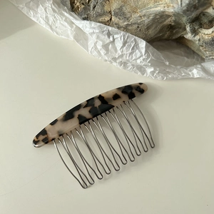 Détail de peigne à cheveux en écaille avec motif léopard poli et dents en métal argenté