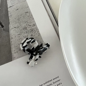Detail of premium marble pattern acetate hair claw clip with glossy finish and metal spring