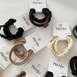 Flat lay of earth-toned high elasticity hair ties with detailed textures and paper tags