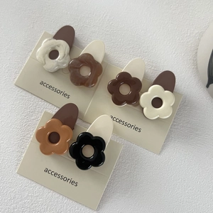 Détail de barrettes à fleurs aux tons terre sur cartes de présentation en acétate