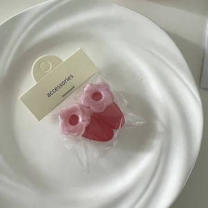 Nahaufnahme süßer rosa Blumen-Haarspangen aus Kunstharz mit Perlmutteffekt auf Karte