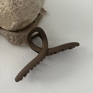 Close-up of 13cm matte coffee brown hair claw clip on stone and paper background
