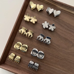 Set of mini heart and smiley face alloy hair clips in gold and silver finish