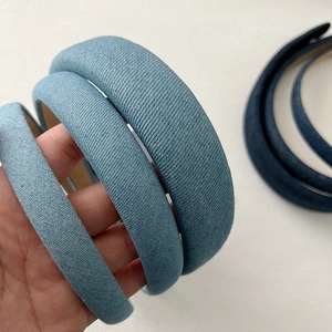 Close-up of three blue padded sponge headbands in different widths and denim textures