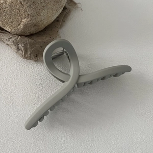 Macro detail of matte grey 13cm hair claw clip with cross design and metal spring mechanism