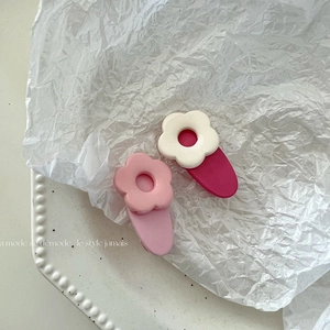 Süße matte Haarspangen mit Blumen in Rosa und Rosarot auf einem Keramiktablett