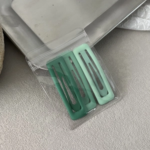 Three-piece set of matte green gradient BB hair clips on a stylish metal tray