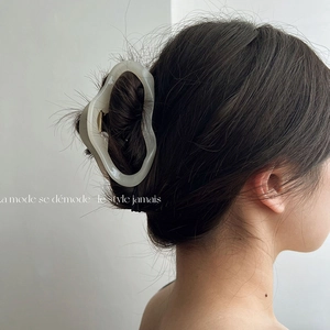 Detail showing an ivory marble hair claw clip on an elegant updo hairstyle