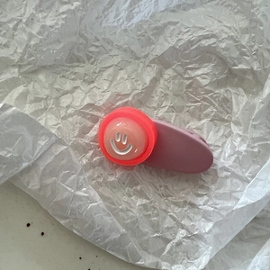 Nahaufnahme einer rosa matten Haarklammer mit niedlichem rotem und weißem Smiley-Motiv