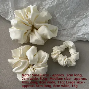 Detailed view of cream satin scrunchies in three sizes with dimensions and weight data