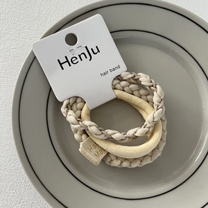 Macro view of cream-colored elastic hair bands with texture and handmade fabric labels