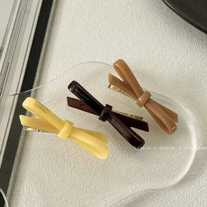 Three-piece acetate bow hair clip set in beige and coffee colors with golden duckbill clips