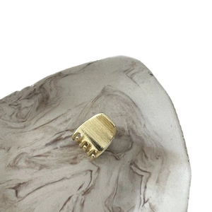 Elegant gold alloy mini hair claw clip with brushed metal finish on marble display