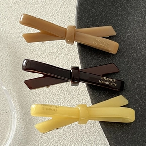Handmade acetate bow hair clips in light brown, dark brown, and yellow colors
