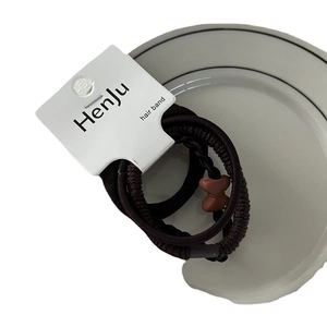 High elasticity dark coffee hair band set with resin bow ornament on a ceramic plate