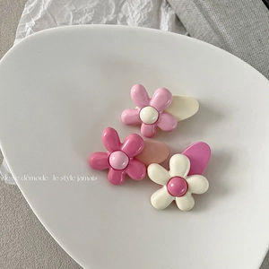 Lot de trois barrettes à fleurs roses et crème sur une assiette blanche élégante