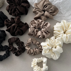 Elegant satin hair scrunchies in various sizes and earth tones like beige and black