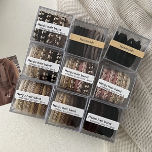 Eight-piece boxed braided elastic hair bands in assorted neutral colors and patterns