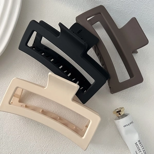 Three oversized matte hair claw clips in black, brown, and cream for thick hair