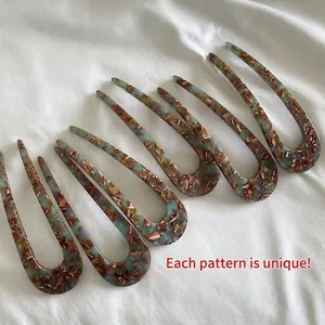 U-shaped hair pin set made of acetate with marble pattern on white fabric