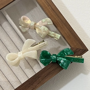 Detail of green and cream acetate bow hair clips with France Handmade golden stamp
