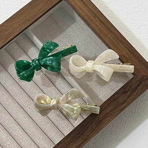 Detailed macro view of three acetate bow hair clips with France Handmade engraving