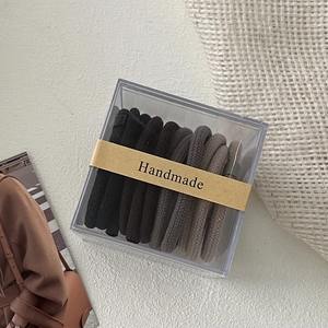 Detail of 10-piece gradient elastic hair ties set in a clear box with handmade label