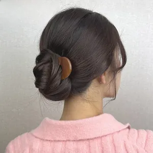 French style amber U-shaped hair pin shown securing a classic bun on a model