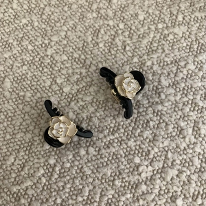 Detail of camellia hair clips with pearl centers and elegant gold-edged petals