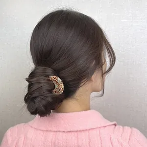 Detail of amber tortoiseshell U-shaped hair pin for French bun styling on model
