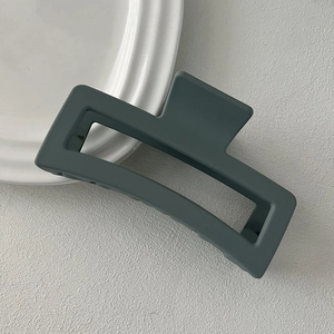 Macro view of a large matte dark gray square hair claw clip for thick hair styling