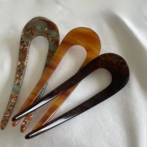 Detailed set of three U-shaped acetate hair pins in marble, amber, and tortoiseshell patterns