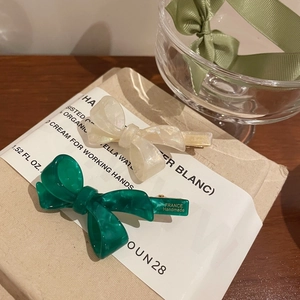 Elegant green and pearl white acetate bow hair clips set with glossy amber texture