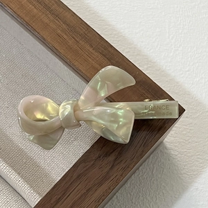 Close-up of acetate bow hair clip showing the detailed France Handmade engraving