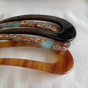 Macro detail of French handmade U-shaped hair pins in three elegant marble patterns