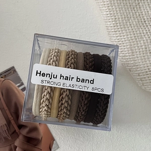 Close-up of 8 high-elasticity braided hair ties in neutral earth tones in a clear storage box