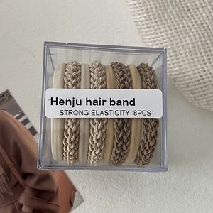 Detail of 8pcs earth-toned elastic hair bands with braided and velvet textures in a box