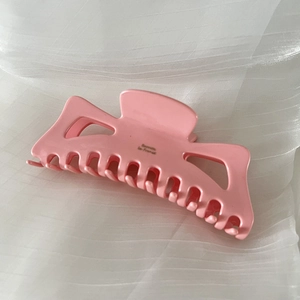Detailed macro view of the pink large hair claw clip with delicate spring mechanism