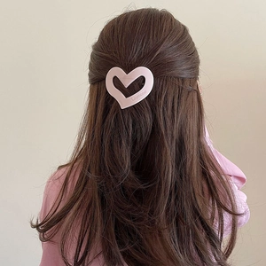 Detailed back view of a pink heart hair claw clip styled on long straight brown hair