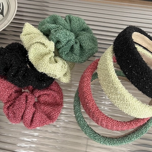 Sparkly tweed hairband and scrunchie set in forest green and beige on a glass tray