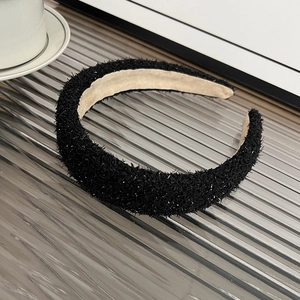 Detail showing the thick black feathered texture and silver sparkles on this padded headband