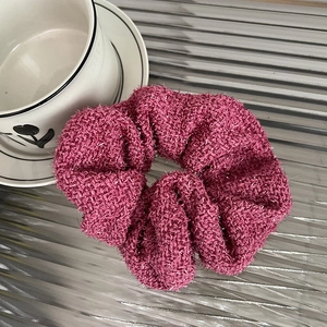 Detailed close-up of a pink plush scrunchie with silver glitter silk and soft texture